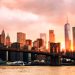 New York, USA. View of Manhattan bridge and Manhattan in New York, USA at sunset. Colorful cloudy sky with skyscrapers. Sun setting behind the skyscrapers