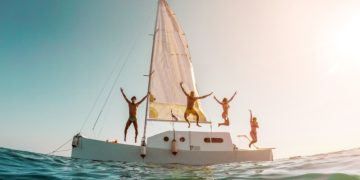 Blurred,Crazy,Friends,Diving,From,Sailing,Boat,Into,The,Sea